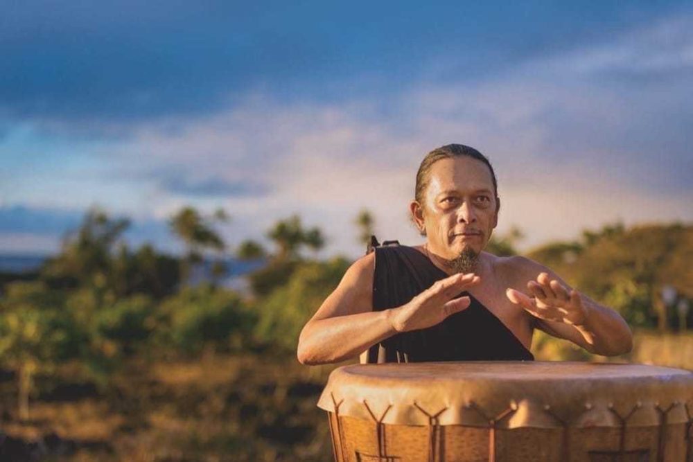 Taro farmer and cultural practitioner Kane Turalde plays the pahu (drum) during a ceremony at Kāneiolouma. Two phases of the restoration have been completed, but much remains. 